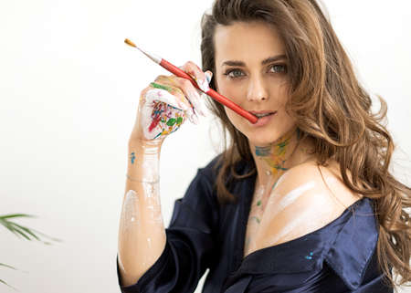 portrait of a beautiful girl in paint posing on a white backgroundの写真素材