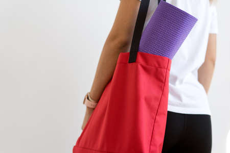 Close up of a womans hands is rolling up exercise mat and preparing to doing yoga.の写真素材