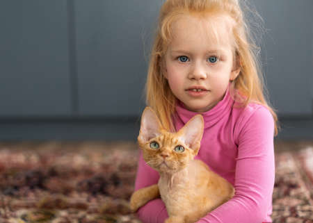 portrait of a little red hair girl with a ginger cat