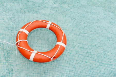 Orange lifeguard floating in swimming pool