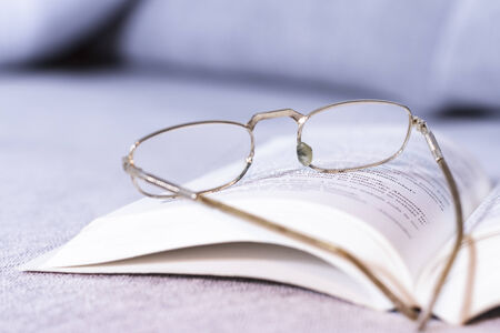Old glasses and open bookの写真素材