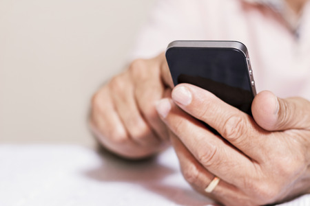 Senior man using smartphone at home の写真素材