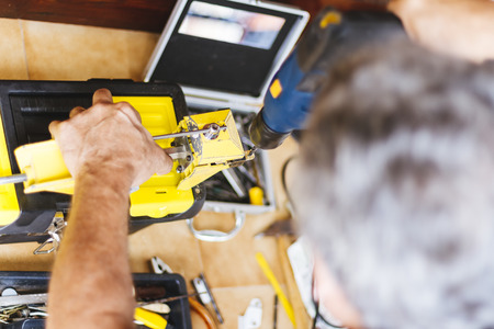 Man with electric drill making hole