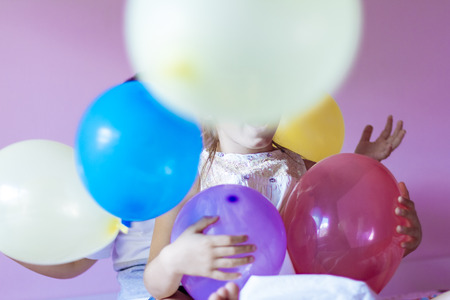 Happy little girl playing with colorful balloonsの写真素材