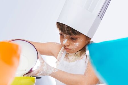 Caucasian girl making a cake, isolated on white backgroundの写真素材