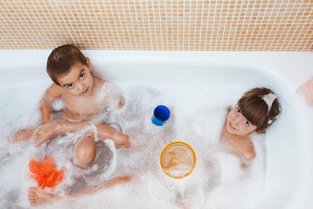 Two brothers playing in the bath together