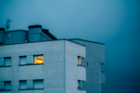 Facade of building in the evening with illuminated windowsの写真素材