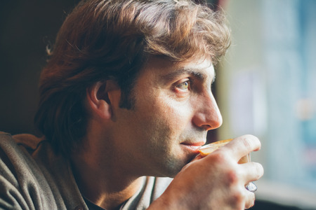 Handsome mature man drinking coffee in the morning at homeの写真素材