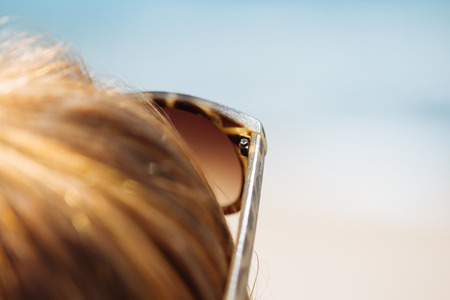 Details of a girl on the beach with sunglasses