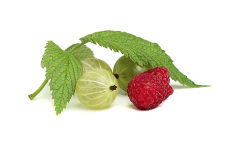 Gooseberries and raspberries with leaves close-up.