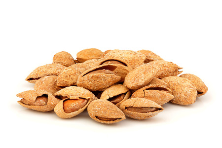 Heap salty almonds in shell isolated on white background.の写真素材