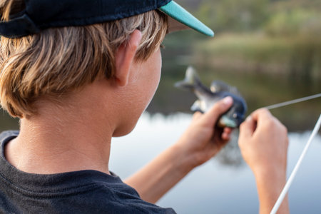 Teenage boy getting fish off the hookの写真素材