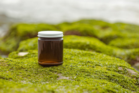 Brown cosmetic container on green mossの写真素材