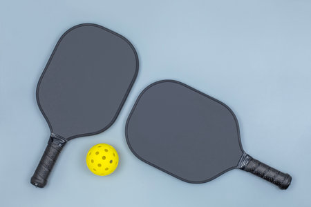 Two pickleball paddles and ball on light grayの写真素材