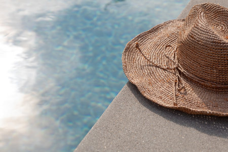 Floppy hat on the edge of a swimming poolの写真素材