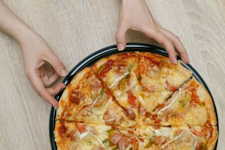 Homemade pizza with sausages, brie cheese, pepper and tomatoes