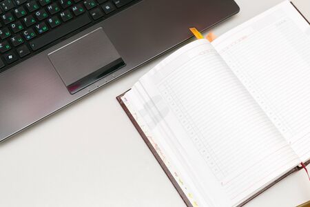 Top view of a laptop, next to which lies a notebookの写真素材