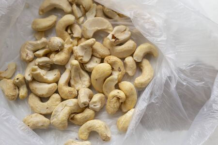 cashew nuts in a plastic bag on white backgroundの写真素材