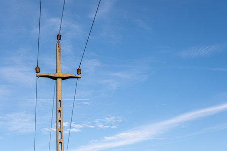 concrete electricity poles with wires against the skyの写真素材