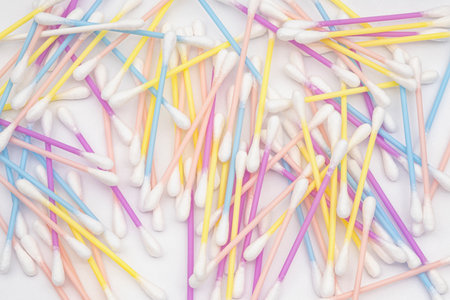 Lot of colored cotton sticks on a white background