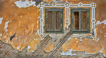 old derelict house with shutters and fallen plaster in Rau Sadului village, Sibiu county, Romaniaの写真素材