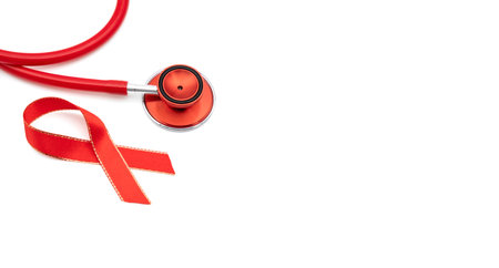 red stethoscope and red silk ribbon symbol of aids awareness on isolated white backgroundの写真素材