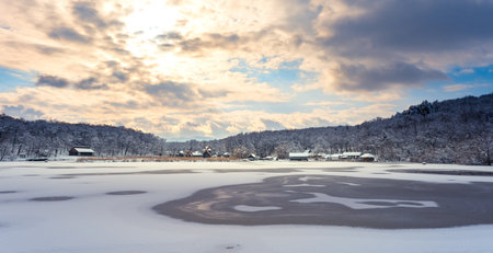Winter panorama with windmills and frozen lake in a cloudy cold dayの写真素材