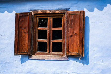 a blue clay house with old wooden window