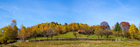 a cottage surrounded by a fence in an atmosphere of autumn with moon, Fantanele village, Sibiu county, Romaniaの写真素材
