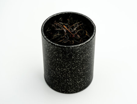 black metal box with black tea leaves