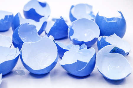 broken empty eggshells on white backgroundの写真素材