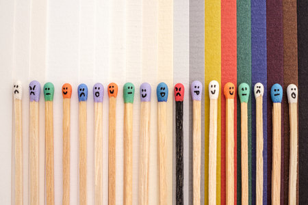 multicolored matchsticks with head faces on multicolored paperの写真素材