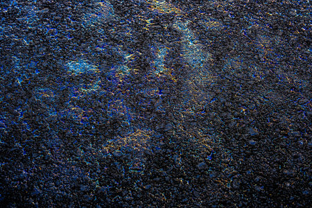 Oil stain on Asphalt road after rain, color Gasoline fuel spots on Asphalt Road