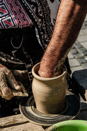Hands of a potter shaping a clay pot on a potter wheelの写真素材