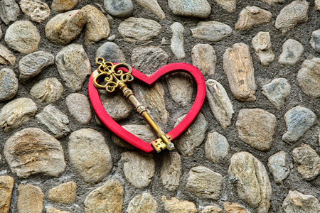 an old key on a red heart on the wall