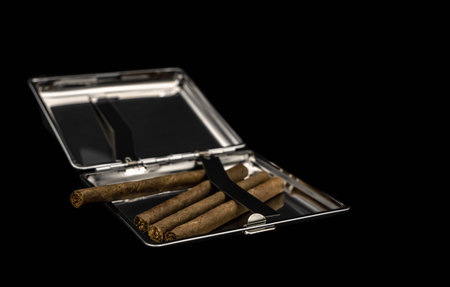 Metal tobacco box with cigarettes on a black backgroundの写真素材