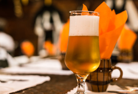 a glass of beer on the table at the restaurantの写真素材