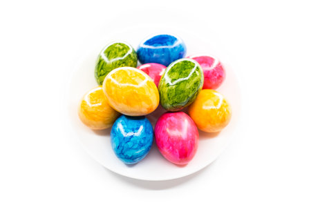 colorful easter eggs in white plateの写真素材