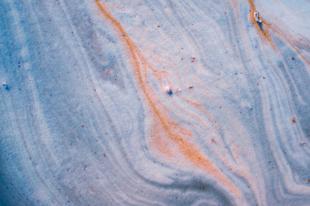 Algae polluted water in brackish water forming colorful patternsの写真素材