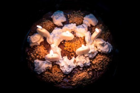 chocolate cake with peanuts and lit candlesの写真素材