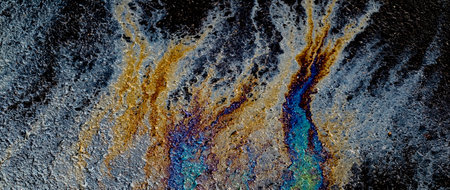 Oil stain on Asphalt road after rain, color Gasoline fuel spots on Asphalt Road
