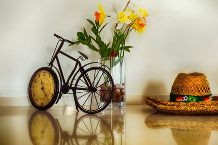 brazilian straw hat on desk with bicycle clock and flower