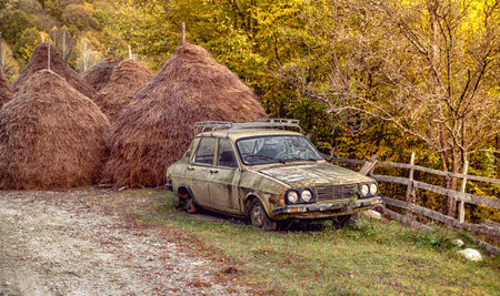 abandoned car in rural scene near haystacks hayの写真素材