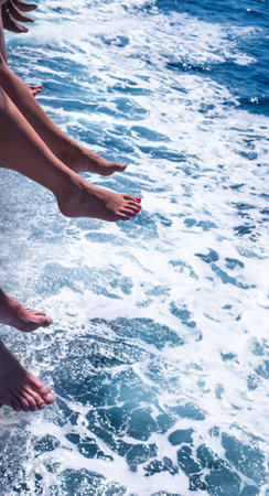 a diversity of man and women feet above the sea blue waterの写真素材