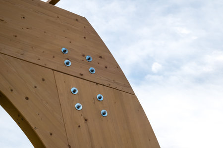 Detail of a modern wooden architecture in glued laminated timber on a blue cloudy skyの写真素材