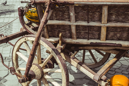 old carriage with rusty wheels and pumpkinsの写真素材