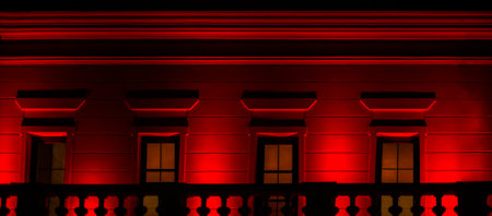 old building illuminated in red at nightの写真素材