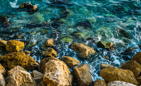 Splashes from the waves bumping against the rocky shoreの写真素材