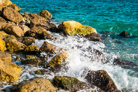 Splashes from the waves bumping against the rocky shoreの写真素材