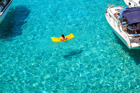 Comino, Malta - July 23, 2019. Tourists crowd at Blue Lagoon to enjoy the clear turquoise water on a...